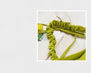 Dettaglio della borsa verde avocado con un particolare manico dal design a nuvola