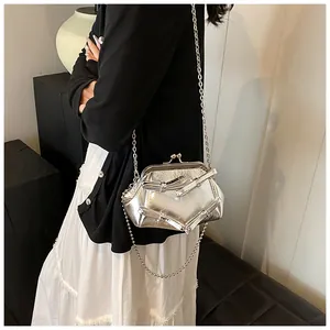 Borsa a tracolla argento metallizzato con fiocco e catena indossata dalla modella