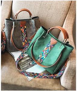 Detail of green and grey suede tote bags with ethnic style geometric woven straps