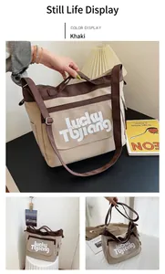 Dettaglio della borsa tote in tela kaki con spalline a contrasto e scritte Lucky TBjiang