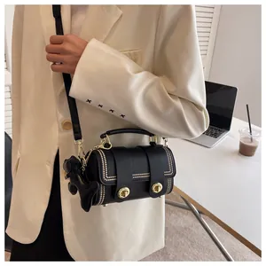 Borsa a cilindro nera alla moda con borchie dorate e ciondolo a forma di cane sul modello