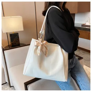 Detailed view of white crocodile pattern tote bag with silver handle and silk scarf