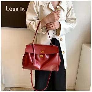 Dettaglio della borsa in pelle rossa con due fibbie a girello dorate e texture pregiata