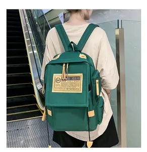 Dettaglio dello zaino verde bosco in nylon resistente con eleganti finiture in pelle marrone