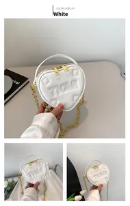Dettaglio della mini borsa bianca a forma di cuore in pelle con catena e rilievo floreale