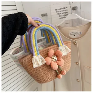 Dettaglio borse intrecciate a mano con manici color arcobaleno e decorazioni floreali