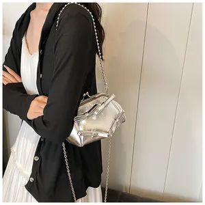 Dettaglio della mini borsa metallizzata argento con fiocchi e catena a sfere