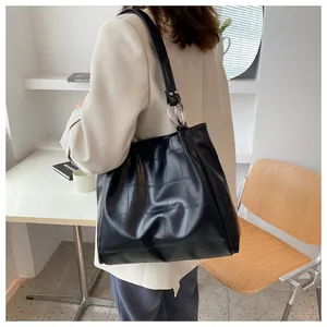 Detail of black crocodile texture tote bag with silver metal ring and wide shoulder strap