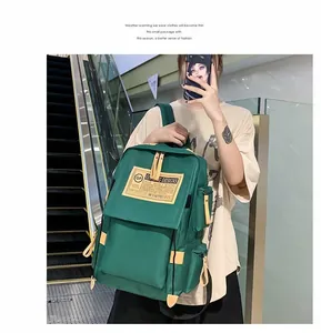 Dettaglio dello zaino in nylon verde scuro con toppa logo gialla e accenti kaki