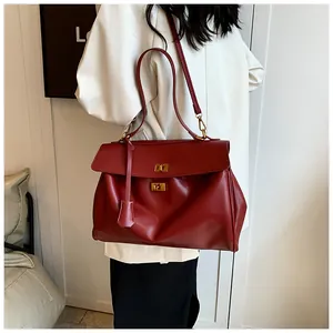 Dettaglio della borsa tote bordeaux con chiusura in metallo dorato e pelle morbida