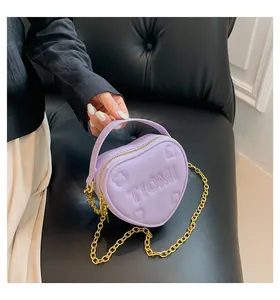 Dettaglio borsa a cuore viola con logo TIOMI goffrato e tracolla a catena dorata