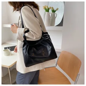 Detail of black glossy tote bag with quilted pattern and stylish silver metal ring detail