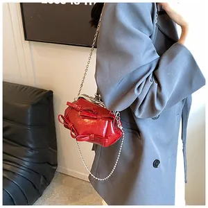 Borsa a tracolla rossa con fiocco, chiusura vintage e catena dorata indossata