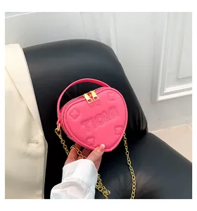 Dettaglio della borsa rosa a cuore con lettere Tiomi goffrate e texture a petali