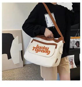 Dettaglio di una grande borsa tote in tela con tracolla regolabile in colore marrone