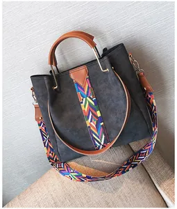 Detail of grey suede tote bag with colorful geometric woven pattern and wide shoulder strap