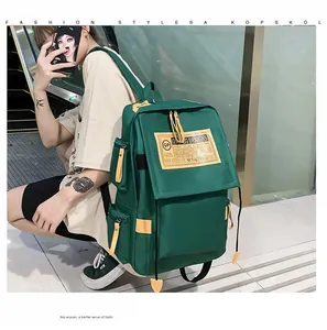 Zaino in tela verde scuro con cinghie gialle a contrasto e tasche laterali multiple