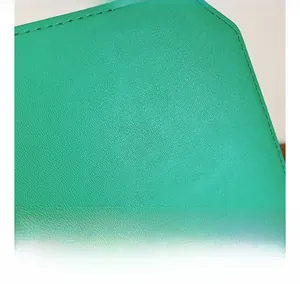 Detail shot of premium green lychee grain leather texture with neat stitching craftsmanship