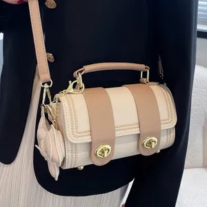 Elegante borsa a tracolla cilindrica color crema e marrone con fiocco e chiusura dorata