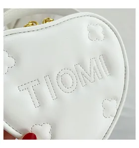 Dettaglio borsa bianca a forma di cuore con trapuntatura TIOMI e cerniere dorate