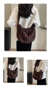 Détail du sac à bandoulière marron foncé avec texture 3D à bulles et sangle large