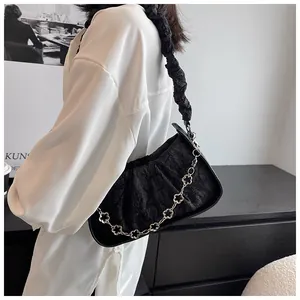 Borsa sottobraccio nera a pieghe con catena a quadrifoglio argento indossata dal modello