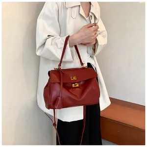 Dettaglio borsa tote bordeaux con chiusure dorate e tracolla regolabile in pelle