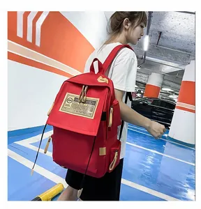 Dettaglio dello zaino casual rosso in nylon con etichetta vintage e cursori in pelle