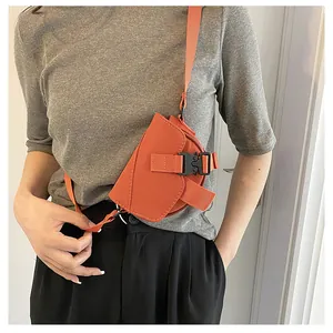 Dettaglio di una mini borsa arancione in nylon con fibbia nera e tracolla funzionale
