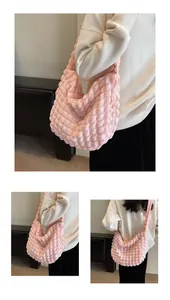 Détail macro du sac à bandoulière rose clair avec texture bulles et tissu plissé