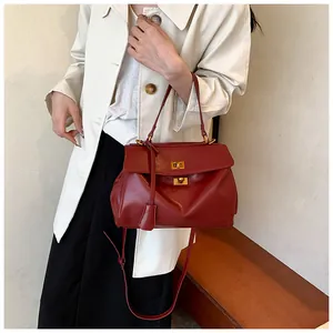 Dettaglio della borsa sottobraccio in pelle rosso vino con eleganti fibbie girevoli oro