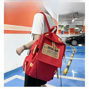 Vista laterale dettagliata di un grande zaino rosso casual indossato da un modello in interno