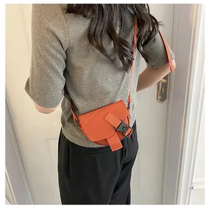 Dettaglio della mini borsa a tracolla in nylon arancione acceso con fibbia in plastica