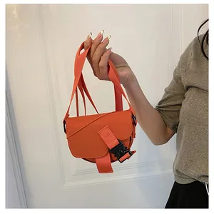 Dettaglio della borsa a sella in nylon arancione con fibbia e tracolla regolabile