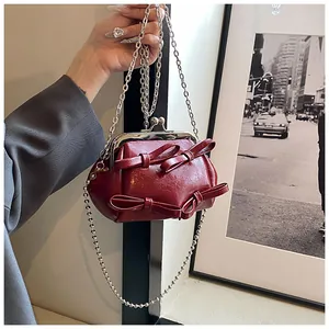 Dettaglio borsa rosso scuro con fiocchi decorativi e chiusura in metallo retrò