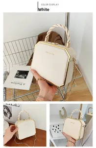 Detailed view of a white octagonal box bag with gold metal corners and chain strap