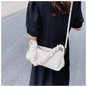 Moderna borsa a spalla arricciata bianco panna con tracolla sottile indossata da modella
