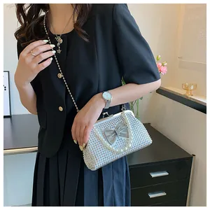 Detail of silver rhinestone evening bag with sparkling bow and elegant pearl handle