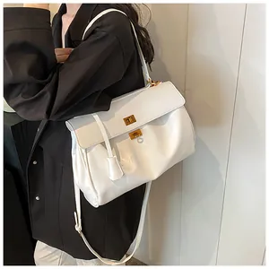 Dettaglio della borsa in pelle bianca con eleganti doppi lucchetti dorati e texture morbida