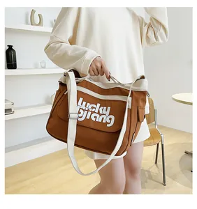 Borsa a tracolla in tela marrone con bordi bianchi a contrasto e stampa Lucky Jiang