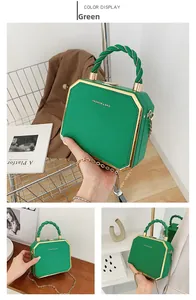 Detail of green hexagonal acrylic handbag with gold metal frame and twisted top handle