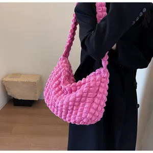 Détail du sac à bandoulière plissé rose vif montrant la texture unique de nuage de bulles