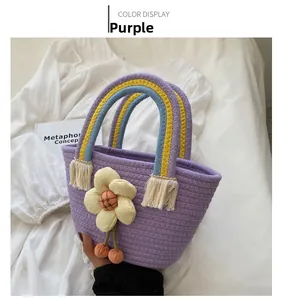 Dettaglio borsa in paglia viola con manici arcobaleno e decorazione floreale a fiori
