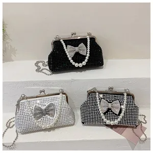 Detailed view of pearl handle and rhinestone bow on glittery evening clutch bags