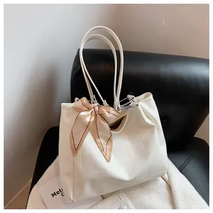 Close-up of white embossed crocodile leather tote bag featuring a decorative silk scarf