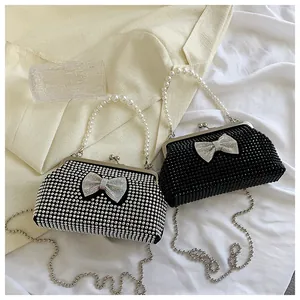 Detail of silver and black rhinestone clutches with pearl handles and crystal bows
