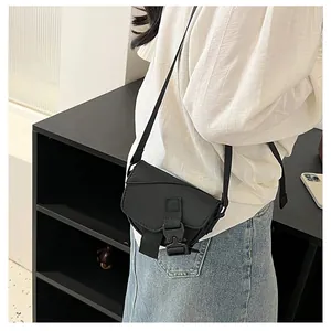 Dettaglio mini borsa a tracolla in nylon nero con fibbia funzionale e cinturino regolabile