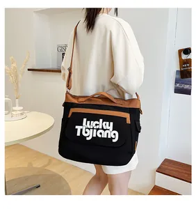 Dettaglio di una borsa a tracolla in tela capiente con design patchwork nero e marrone