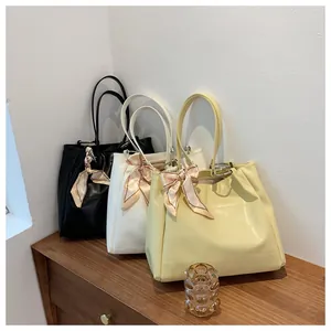 Minimalist large tote bags in black, white, and yellow with decorative silk scarves and rings