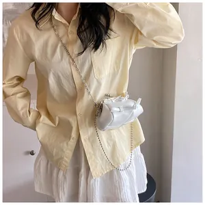 Dettaglio della mini borsa bianca in pelle PU con fiocco e catena a sfere argentate